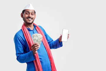 Wall Mural - Young indian farmer showing smartphone and money on white background.