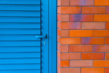 Photo of abstract combination of color, blue steel daor, red brick