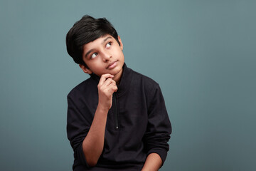 Canvas Print - Little boy of Indian ethnicity looking up and thinking