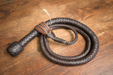 Closeup shot of a Nagaika whip on a wooden surface