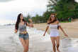 © sutthichai - Two female walking on the beach .holiday and vacation concept.