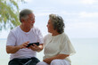 © sutthichai - Happy Asian senior couple enjoy playing smartphone outdoor. Retirement and love concept.