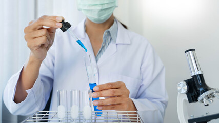 Scientist wear lab coat and protective wear are working with research or doing investigations with test tubes in experiment, Laboratory and development concept