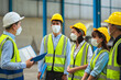 © SEVENNINE_79 - The factory employee consists of engineers, foreman, technicians, and related department staff. Wear a mask, hard hat, and vest. meeting before starting work inside the warehouse. Teamwork concept.