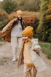 © Ananass - Young happy and smiling mom with her little daughter in arms hugging and kissing spending a weekend on a walk in autumn park. selective focus, noise effect, Autumnal mood