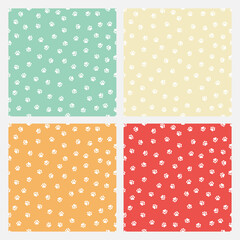 Set of 4 colorful seamless patterns with white paws.