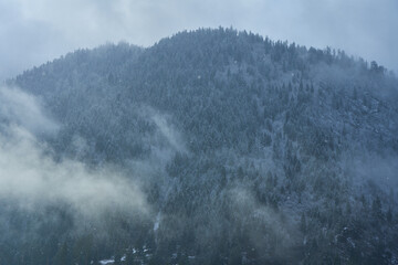 Wall Mural - Winter mountain landscape. Small town between mountains. A cloud hangs over the city