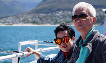 Asian Senior Elderly Couple On Tourist Ferry Boat To Seals Island Trip Attracion Fun Wildlife Watching Aticity In South Africa Trip