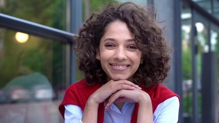 Young confident woman freelancer using laptop computer, looking at camera and smiling, sitting at workplace, slow motion 