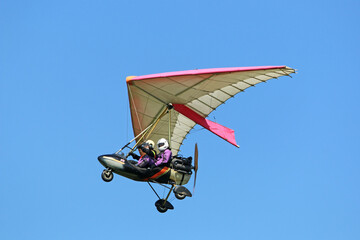 Poster - Ultralight airplane flying in a blue sky	