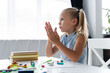 © LIGHTFIELD STUDIOS - blonde preschooler girl molding plasticine in private kindergarten