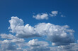 White flocky clouds over blue sky background. Beautiful view of natural scene at sunny day.