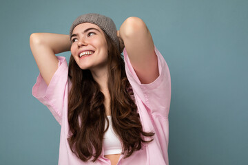 Beautiful positive happy young dark brunette woman isolated over colourful background wall wearing casual stylish clothes feeling sincere emotions looking to the side