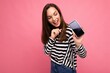 Charming funny adult female person wearing striped sweater isolated over background with copy space looking at telephone showing mobile phone screen