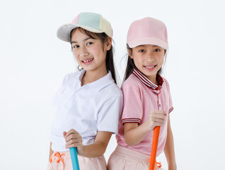 Portrait isolated studio shot of two Asian little professional girl golfers in sport fashion clothing uniform stand lean on each other back hold putter grip on green grass in front white background