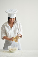 Wall Mural - woman in chef's uniform working with dough flour products cooking