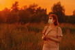 © Nadezhda - Redhead girl young wearing face mask outside during Coronavirus COVID-19 quarantine. Middle age woman walking in summer meadow alone and dreaming.