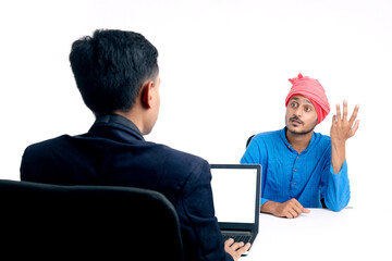 Young indian banker giving some information to farmer at office.