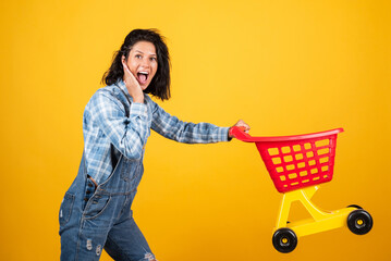 Home shopping. shopper girl have fun. marketing concept. Female housewife with shopping trolley in supermarket. girl pushing shopping cart in the mall. happy woman carry shopping cart