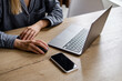© Iuliia Pilipeichenko - The girl sits at the table and works at a laptop and a smartphone. Remote work from home, cafe, business space. Business lady at work. Business background. Home office