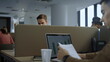 © stockbusters - Focused businessman using laptop at workplace. Professional holding documents