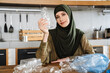 © Drobot Dean - Young muslim woman wearing hijab separating waste while sitting at table