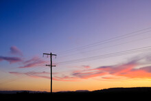 Horizontal Shot Of A Sunset With A Silhouette Of An Electrical Post With Wires