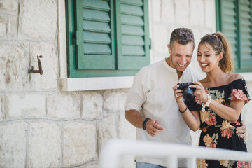 Canvas Print - Couple Using Digital Camera While Enjoying Summer Holiday