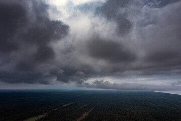 Wall Mural - Cloudy sky over land in summer time.