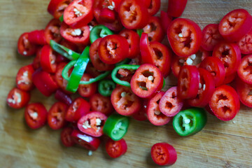 Sticker - Closeup of red and green chili peppers on a wooden table