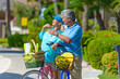 Happy senior couple exercising with bicycles in the park on a sunny day