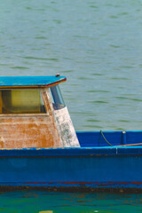 Sticker - Closeup view of the rusty old boat with blue paint floating on the surface of the water