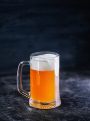 Wall Mural - A mug of beer on a black wooden table