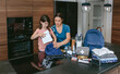 © David Pereiras - Mother preparing emergency backpack with her daughter in the kitchen