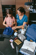 © David Pereiras - Aerial view of mother preparing emergency backpack with her daughter in the kitchen