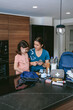 © David Pereiras - Mother explaining to her daughter how to prepare an emergency backpack in the kitchen