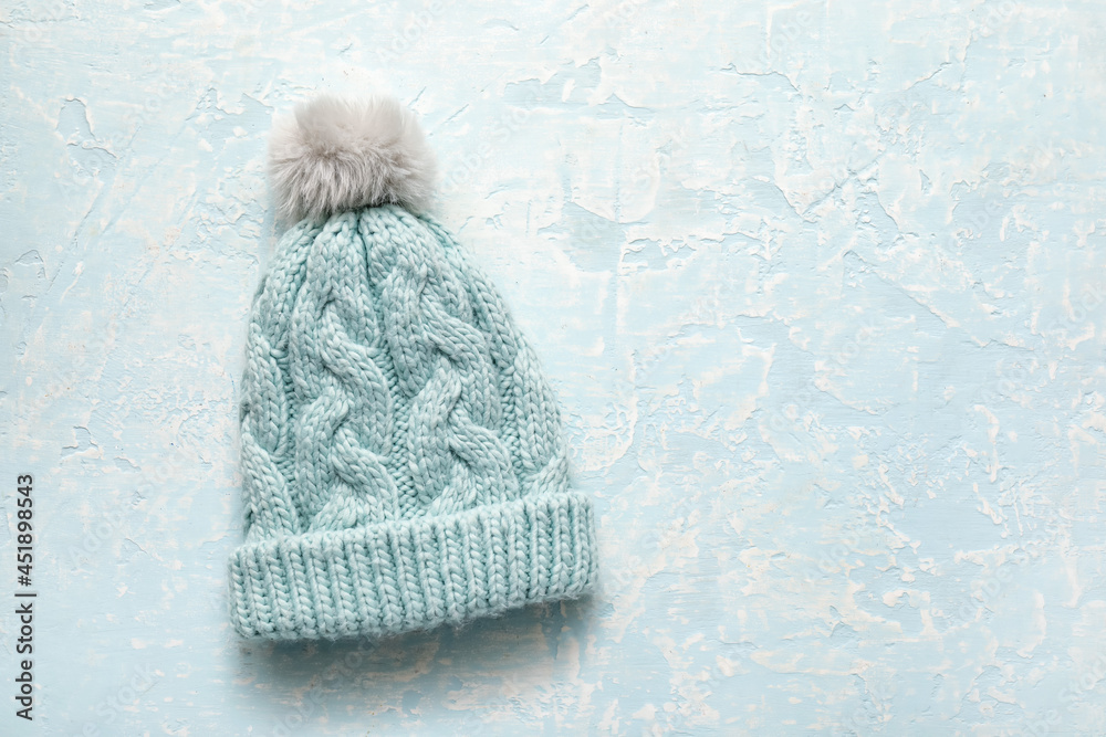 Stylish warm hat on color background