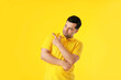 © Pixel-Shot - Handsome young man pointing at something on color background
