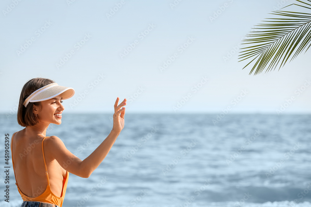 Beautiful young woman on sea beach at tropical resort - obrazy, fototapety, plakaty 