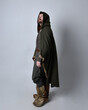 Full length  portrait of  young handsome man  wearing  medieval Celtic adventurer costume with hooded fur cloak, standing pose  isolated on studio background.