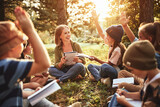 Fototapeta  - Kids raising hands asking questions during outdoor lesson with teacher in forest on sunny spring day