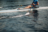 Sportsman single scull man rower rowing on boat. Oar paddle water splash movement