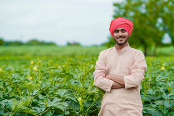 Young Indian farmer at green agriculture field.