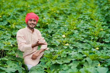 Young Indian farmer at green agriculture field.