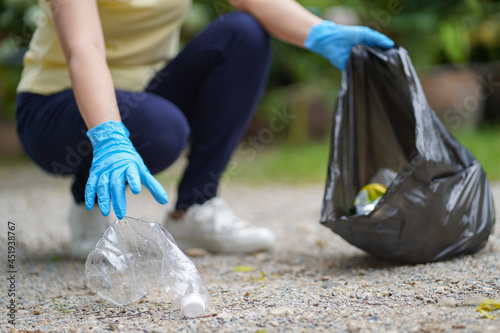 Volunteer charity woman hand holding garbage black bag and plastic bottle garbage for recycling for cleaning at park volunteering concept reuse and volunteer helping