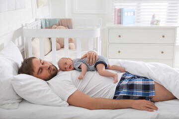 Wall Mural - Tired young father sleeping with his baby in bed at home