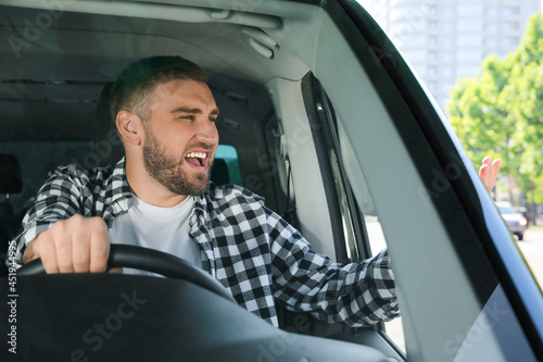 Emotional man in car. Aggressive driving behavior