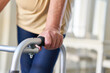 Senior Patient mit Behinderung stützt sich auf einen Rollator