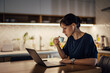 © bnenin - Tired businesswoman drinking cup of coffee while working late at night.
