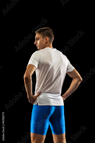 Portrait of Caucasian professional male athlete in sports uniform isolated on dark studio background. Muscular, sportive man. Concept of action, motion, youth, healthy lifestyle.